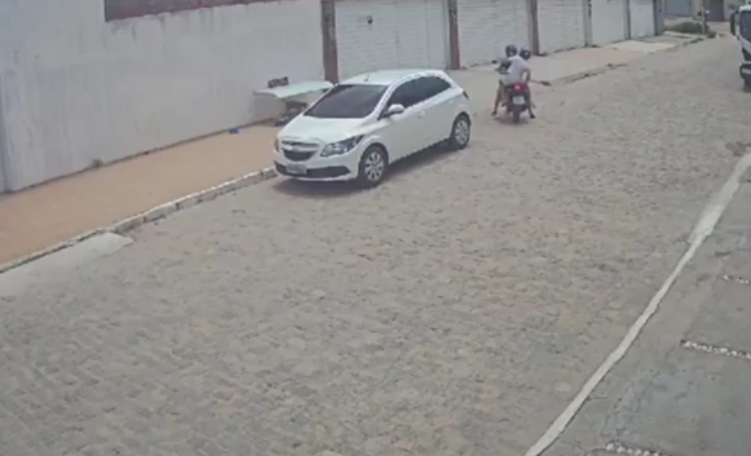 O equipamento de segurança gravou o momento em que as duas mulheres descem de uma moto com os animais dentro do recipiente/Foto: Reprodução O equipamento de segurança gravou o momento em que as duas mulheres descem de uma moto com os animais dentro do recipiente/Foto: Reprodução