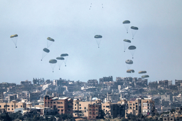 Foto tirada da fronteira sul de Israel com a Faixa de Gaza mostra ajuda humanitária sendo lançada de avião sobre o território palestino/Créditos: JACK GUEZ / AFP Foto tirada da fronteira sul de Israel com a Faixa de Gaza mostra ajuda humanitária sendo lançada de avião sobre o território palestino/Créditos: JACK GUEZ / AFP
