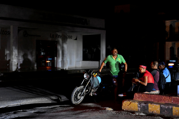 Pessoas numa rua escura durante um apag&atilde;o no munic&iacute;pio de Bauta, prov&iacute;ncia de Artemisa, Cuba/Cr&eacute;dito: YAMIL LAGE / AFP