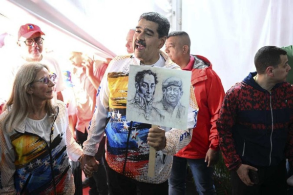 Acompanhado da primeira-dama Cilia Flores, Nicolás Maduro exibe imagens de Simón Bolívar e de Hugo Chávez, ao visitar o Conselho Nacional Eleitoral/Crédito: Federico Parra/AFP Acompanhado da primeira-dama Cilia Flores, Nicolás Maduro exibe imagens de Simón Bolívar e de Hugo Chávez, ao visitar o Conselho Nacional Eleitoral/Crédito: Federico Parra/AFP