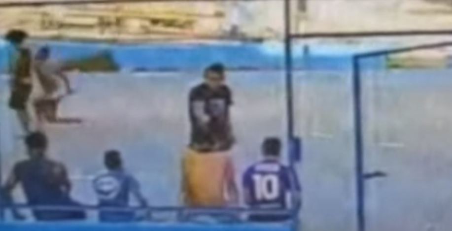 Homem de camisa preta atira em rapaz em quadra de futebol/Foto: Redes Sociais Homem de camisa preta atira em rapaz em quadra de futebol/Foto: Redes Sociais