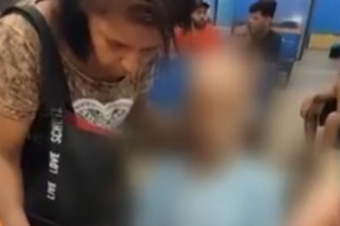 Érika ficou a todo momento tentando manter a cabeça do homem reta, enquanto fingia estar falando com ele/foto: Reprodução/Redes sociais Érika ficou a todo momento tentando manter a cabeça do homem reta, enquanto fingia estar falando com ele/foto: Reprodução/Redes sociais