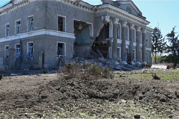 Cratera e um edif&iacute;cio danificado no local de um ataque, na aldeia de Zolochiv, regi&atilde;o de Kharkiv/Cr&eacute;dito: SERGEY BOBOK / AFP