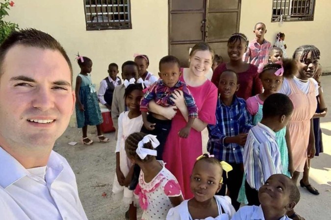Os missionários norte-americanos Davy e Natalie Lloyd posando com crianças haitianas/MISSIONS IN HAITI / AFP Os missionários norte-americanos Davy e Natalie Lloyd posando com crianças haitianas/MISSIONS IN HAITI / AFP