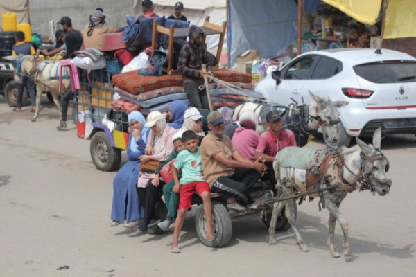 Palestinos chegam de carroça puxada por burro, em Khan Yunis, depois de fugirem de Rafah/Crédito: Bashar Taleb/AFP