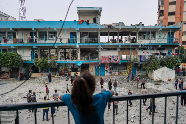 Uma menina palestina observa enquanto outras pessoas verificam uma escola da ONU que abriga pessoas deslocadas que foi atingida durante o bombardeio israelense em Nuseirat, no centro da Faixa de Gaza/Crédito: BASHAR TALEB / AFP Uma menina palestina observa enquanto outras pessoas verificam uma escola da ONU que abriga pessoas deslocadas que foi atingida durante o bombardeio israelense em Nuseirat, no centro da Faixa de Gaza/Crédito: BASHAR TALEB / AFP