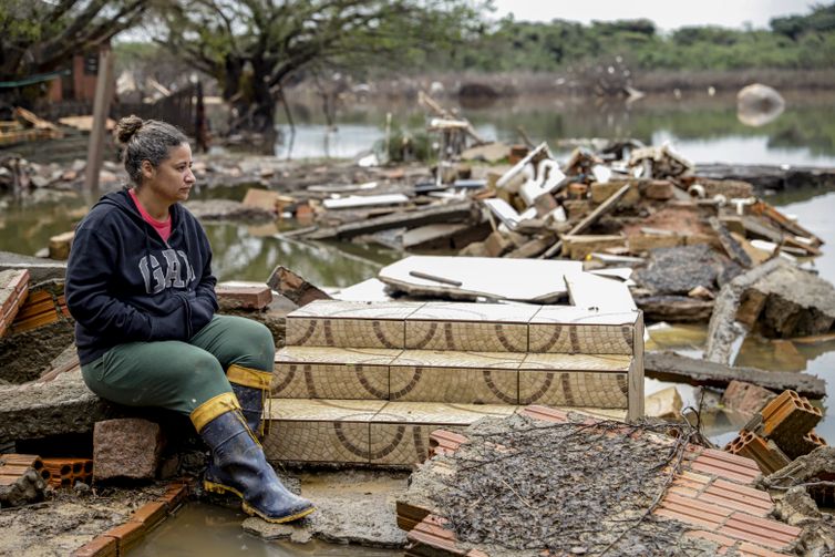 Moradora em frente ao que sobrou da sua casa/foto: Bruno Peres/Agência Brasil