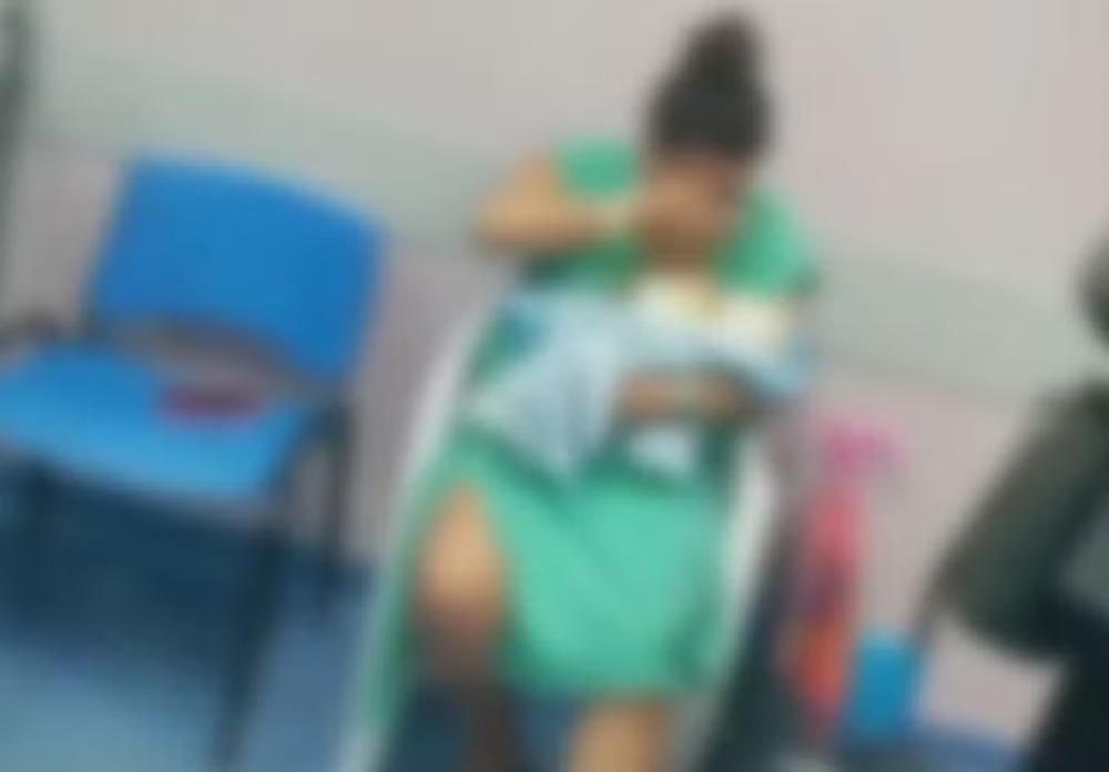 A paciente em um vídeo em que aguarda sentada para receber atendimento após contrair infecção operatória/Foto: Reprodução/Redes Sociais A paciente em um vídeo em que aguarda sentada para receber atendimento após contrair infecção operatória/Foto: Reprodução/Redes Sociais