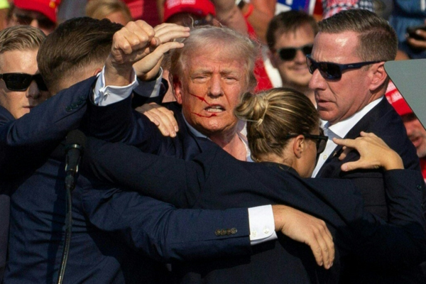Trump acenando para os seus apoiadores após ter sofrido um atentado/Crédito: REBECCA DROKE / AFP