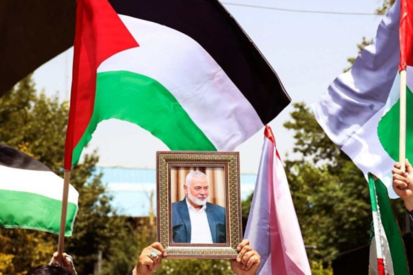Pessoas exibem bandeiras palestinas e o retrato de Ismail Haniyeh durante marcha na capital iraniana: luto de três dias/Crédito: AFP