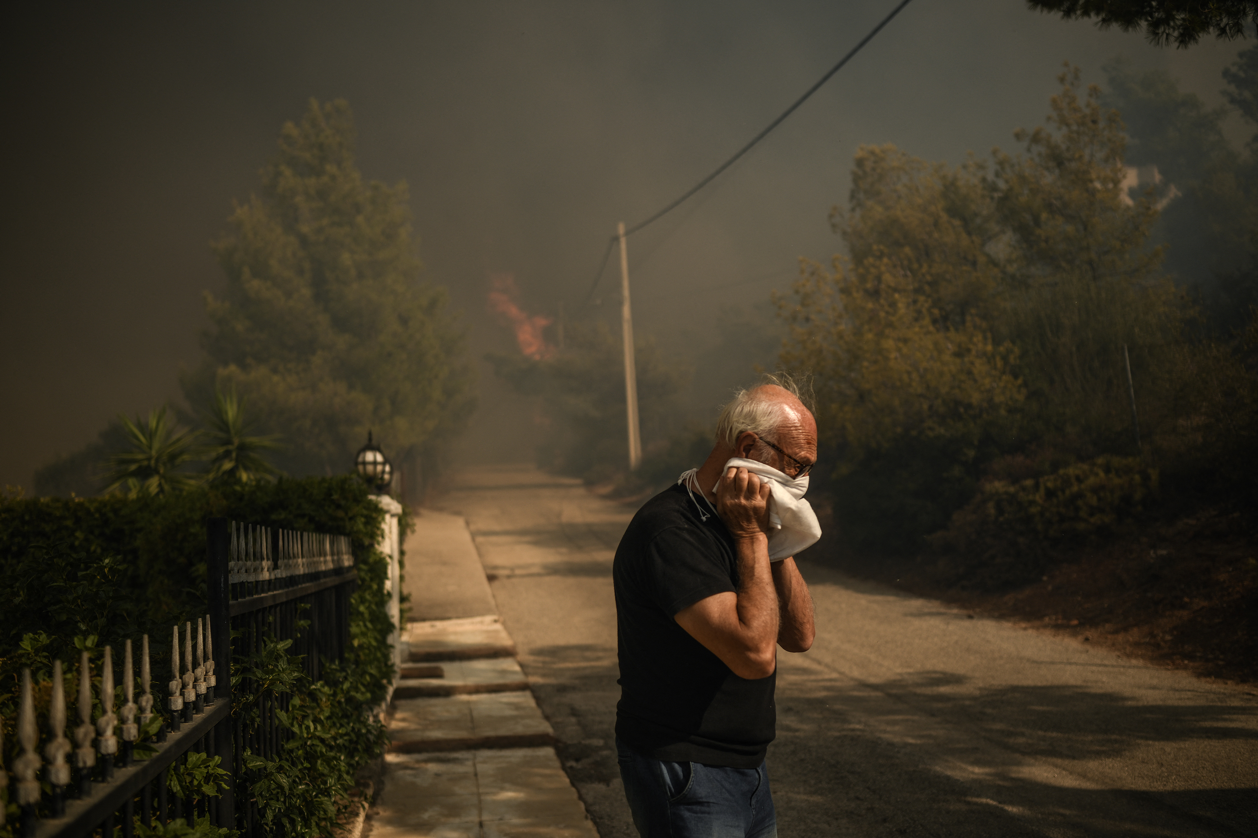 Residente local reage ao assistir a um incêndio florestal em Dione em 12 de agosto de 2024/Foto: Angelos TZORTZINIS / AFP Residente local reage ao assistir a um incêndio florestal em Dione em 12 de agosto de 2024/Foto: Angelos TZORTZINIS / AFP