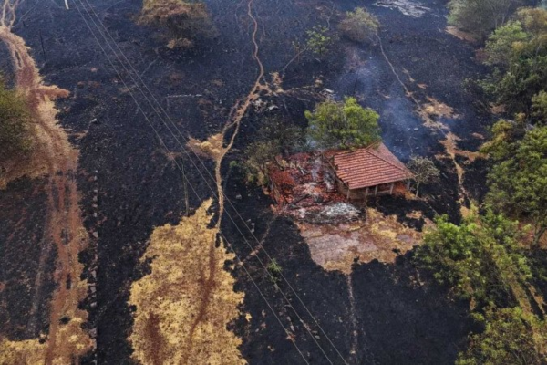 Casa destruída por um incêndio no entorno da rodovia SP-330 em Ribeirão Preto, em 25 de agosto/Crédito: CARLOS FABAL / AFP
