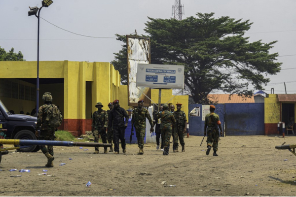 Reforços militares caminham na entrada da Prisão de Makala em Kinshasa/Crédito: HARDY BOPE / AFP Reforços militares caminham na entrada da Prisão de Makala em Kinshasa/Crédito: HARDY BOPE / AFP