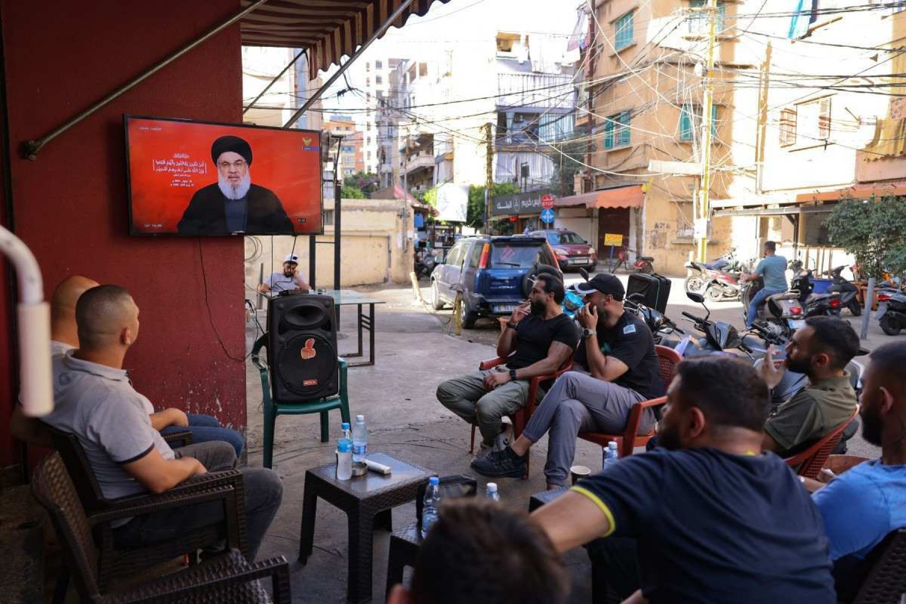 Moradores do bairro de Shiyah, no sul de Beirute, assistem ao discurso de Hassan Nasrallah em cafeteria