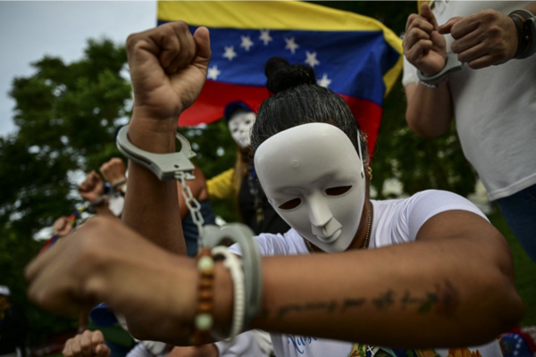 Uma mulher algemada participa de uma manifestação para protestar contra o regime venezuelano/Crédito: MARTIN BERNETTI / AFP Uma mulher algemada participa de uma manifestação para protestar contra o regime venezuelano/Crédito: MARTIN BERNETTI / AFP