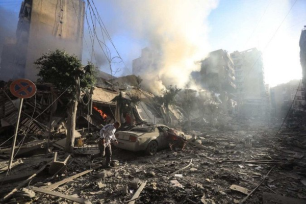Morador de Beirute caminha sobre escombros de prédio destruído durante ataque aéreo israelense, no bairro de Moawwad (sul)/Crédito: AFP