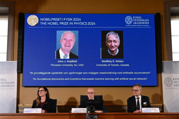 Uma tela mostra os ganhadores do Prêmio Nobel de Física de 2024, o físico norte-americano John J Hopfield e o cientista da computação e psicólogo cognitivo canadense-britânico Geoffrey E Hinton/Crédito: JONATHAN NACKSTRAND / AFP Uma tela mostra os ganhadores do Prêmio Nobel de Física de 2024, o físico norte-americano John J Hopfield e o cientista da computação e psicólogo cognitivo canadense-britânico Geoffrey E Hinton/Crédito: JONATHAN NACKSTRAND / AFP
