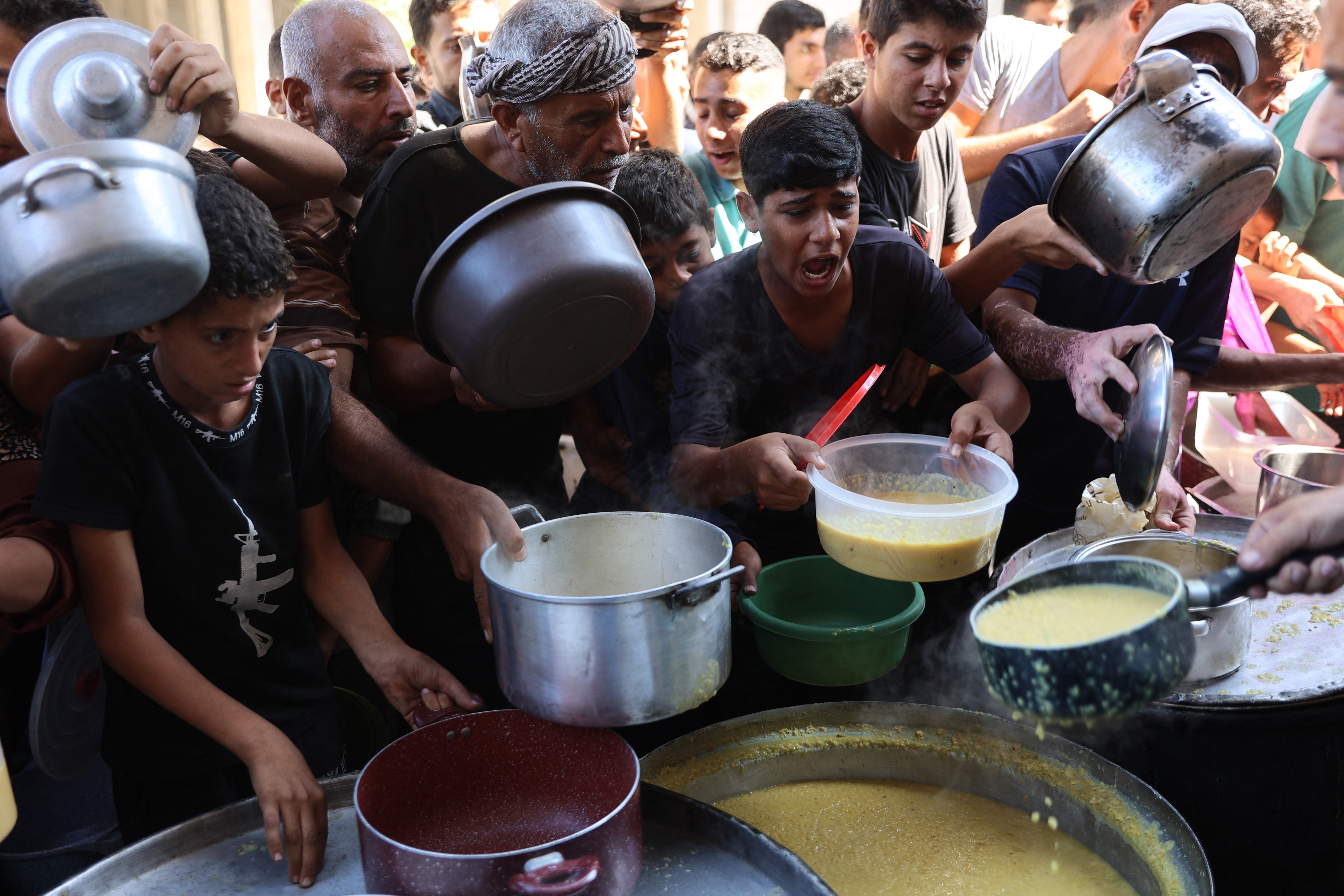 Palestinos deslocados fazem fila para receber rações alimentares, oferecidas por uma instituição de caridade, no campo de refugiados de Al-Shati, em Gaza/Foto: Omar AL-QATTAA / AFP Palestinos deslocados fazem fila para receber rações alimentares, oferecidas por uma instituição de caridade, no campo de refugiados de Al-Shati, em Gaza/Foto: Omar AL-QATTAA / AFP