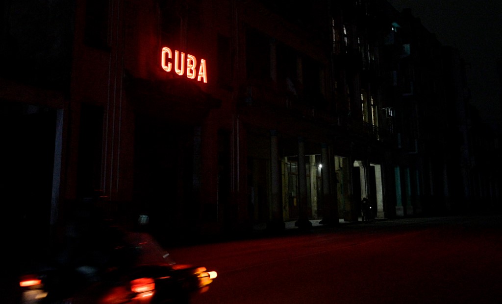 Uma placa ilumina uma rua escurecida durante o segundo dia do apagão nacional em Havana/Foto: ADALBERTO ROQUE / AFP