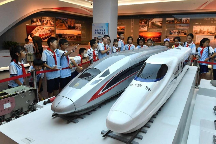 Alunos do ensino fundamental observam modelos de trens de alta velocidade no museu ferroviário de Qingdao.
