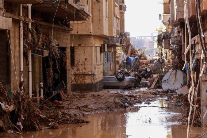 Carros capotados estavam entre outros destroços causados pelas inundações repentinas em Derna, no leste da Líbia, em 2023/Foto: AFP Carros capotados estavam entre outros destroços causados pelas inundações repentinas em Derna, no leste da Líbia, em 2023/Foto: AFP
