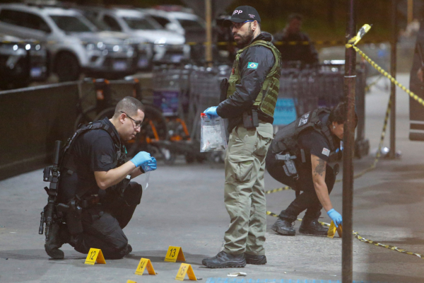 Policiais fazem perícia na área onde o empresário foi morto ao desembarcar no Aeroporto de Guarulhos/Crédito: AFP