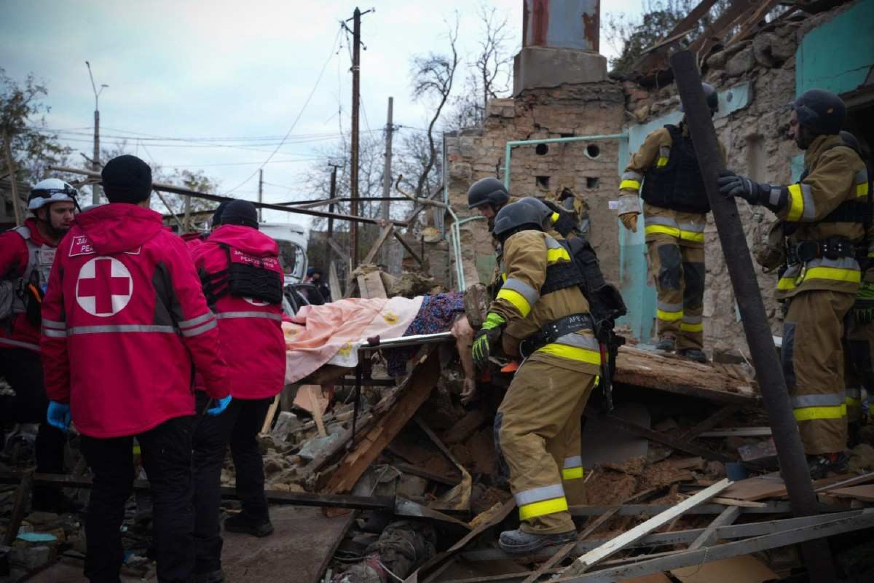 Socorristas ucranianos carregam o corpo de civil morto em ataque com drone na cidade de Mykolaiv (sul)