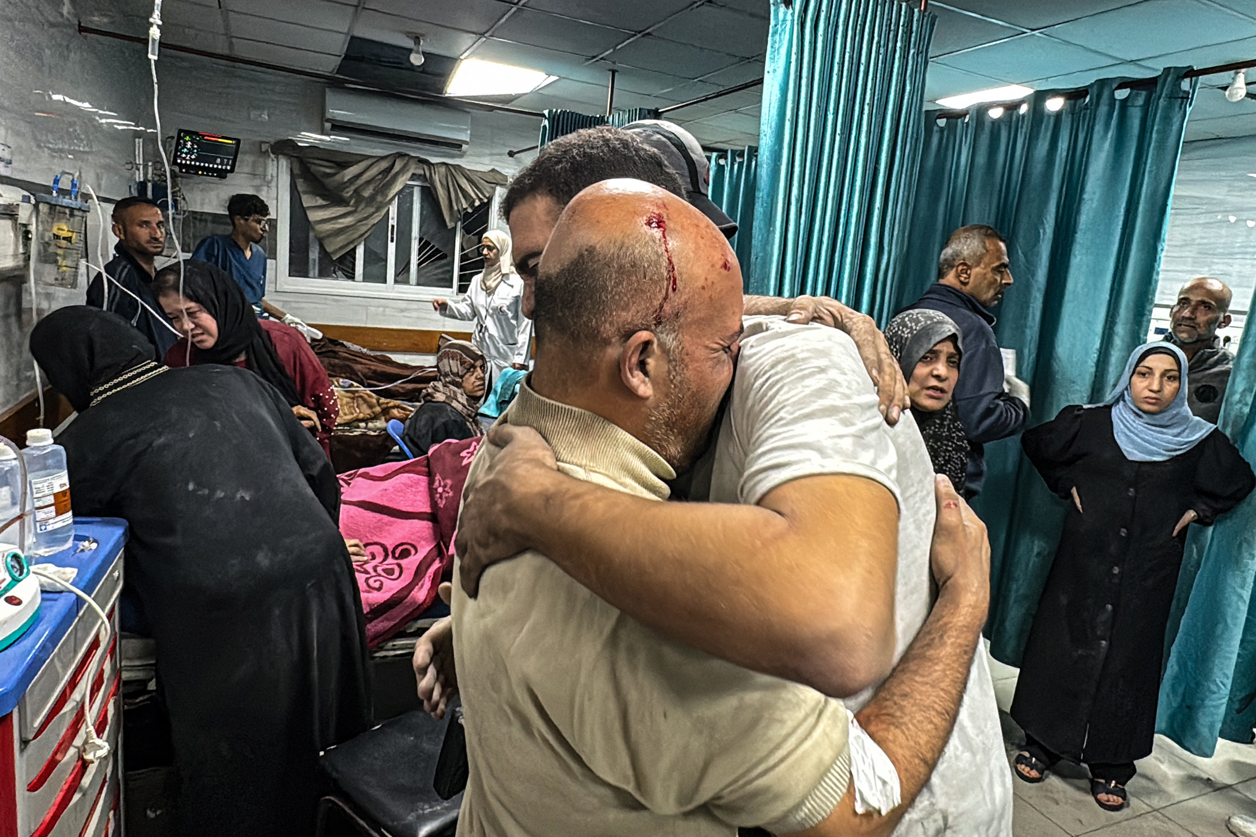 Pessoas se confortam dentro do hospital Kamal Adwan, enquanto vítimas recebem atendimento médico após um ataque israelense que atingiu uma área perto do estabelecimento médico em Beit Layia, no norte da Faixa de Gaza/Foto: AFP Pessoas se confortam dentro do hospital Kamal Adwan, enquanto vítimas recebem atendimento médico após um ataque israelense que atingiu uma área perto do estabelecimento médico em Beit Layia, no norte da Faixa de Gaza/Foto: AFP