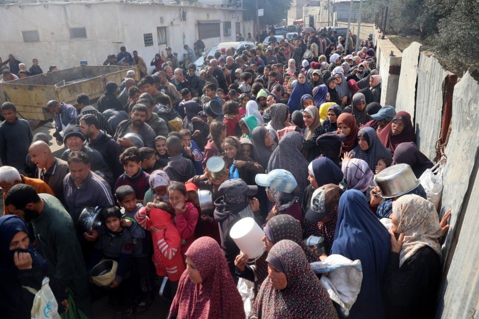 Palestinos se re&uacute;nem para receber alimentos de ajuda que est&atilde;o sendo distribu&iacute;dos em Deir al-Balah, no centro da Faixa de Gaza/Foto: Eyad BABA/AFP