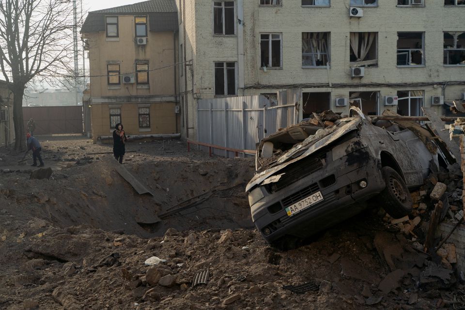 Mulher fica ao lado de uma cratera e de um veículo destruído após um ataque com mísseis em Kiev/Foto: Tetiana DZHAFAROVA/AFP Mulher fica ao lado de uma cratera e de um veículo destruído após um ataque com mísseis em Kiev/Foto: Tetiana DZHAFAROVA/AFP