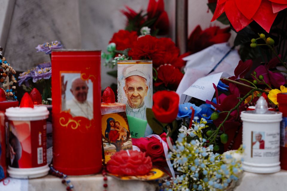 Velas e flores são colocadas na estátua de João Paulo II no Hospital Universitário Gemelli, onde o Papa Francisco está hospitalizado com pneumonia/Foto: Dimitar DILKOFF/AFP