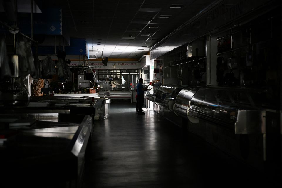 Um homem e uma criança caminham por um mercado local durante um grande corte de energia em Vigo, noroeste da Espanha/Foto: MIGUEL RIOPA/AFP Um homem e uma criança caminham por um mercado local durante um grande corte de energia em Vigo, noroeste da Espanha/Foto: MIGUEL RIOPA/AFP