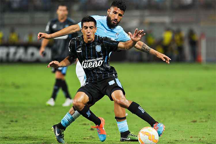 Diego Milito recebe a marcação de Ballon: experiente atacante foi decisivo na vitória do Racing no Peru