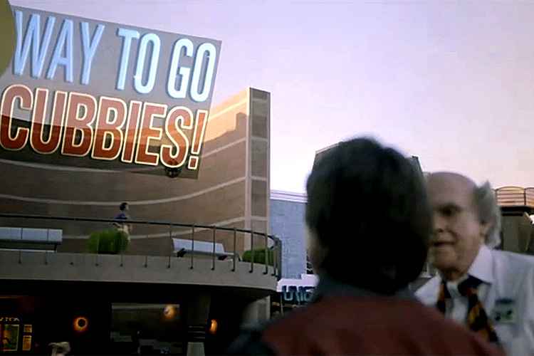 Após chegarem em 2015, Marty McFly e o Dr Emmett Brown admiram painel que parabeniza o Chicago Cubs