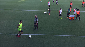 Carlos, de verde, corre ao lado do campo