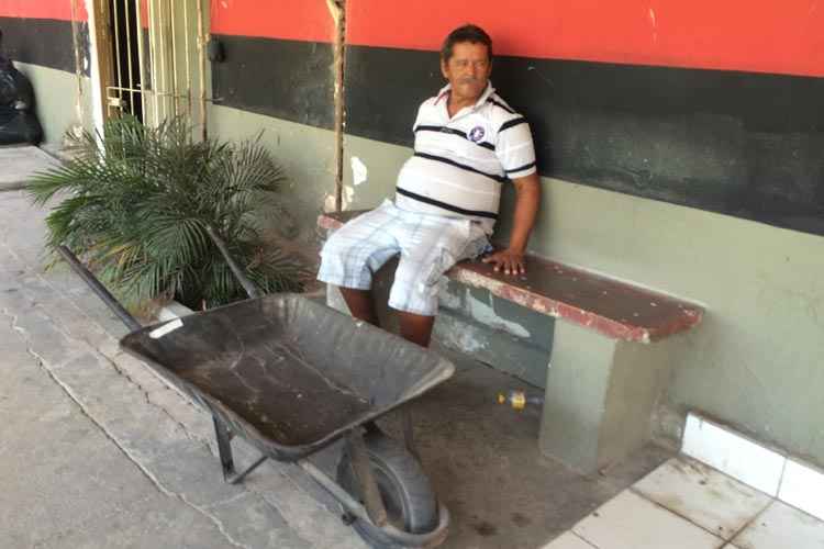 Sentado em frente ao carro de mão doado por Cléber Santana, Nó lamenta tragédia com ex-atleta do Sport