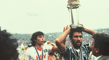 Hugo De León, capitão do time do Grêmio, carrega a taça do título mundial do clube, em 1983