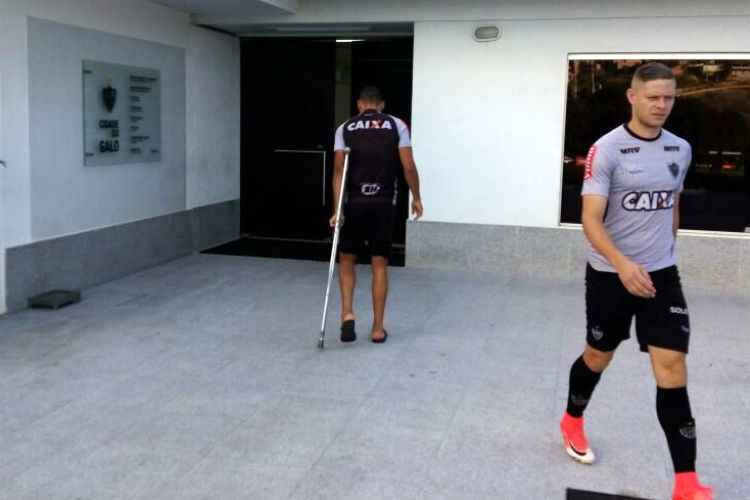 Com entorse no tornozelo esquerdo, Alex Silva (e) caminha com auxílio de muleta na Cidade do Galo