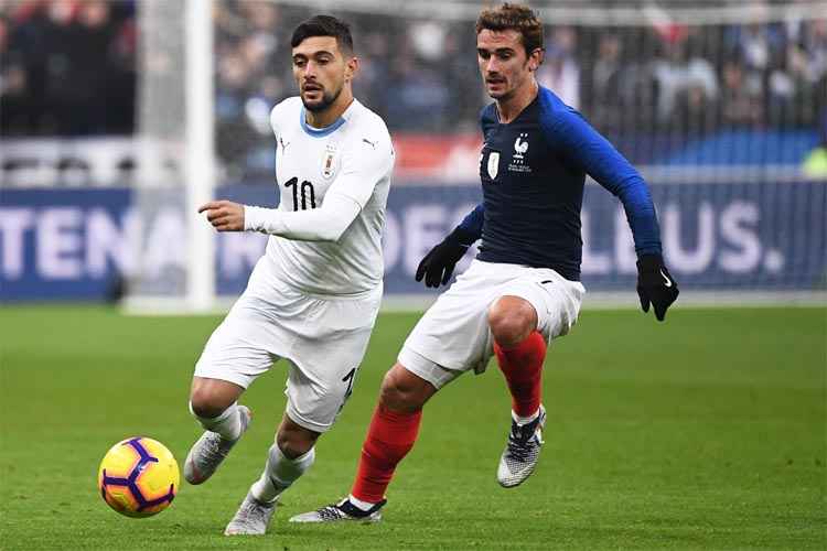 Arrascaeta disputa bola com francês Antoine Griezmann em amistoso desta terça-feira, em Saint-Denis