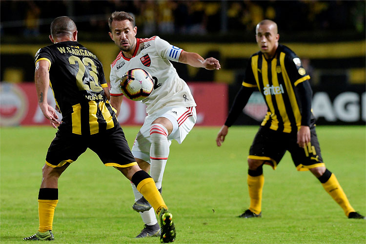 Everton Ribeiro disputa lance com defesa uruguaia: Flamengo alivia pressão