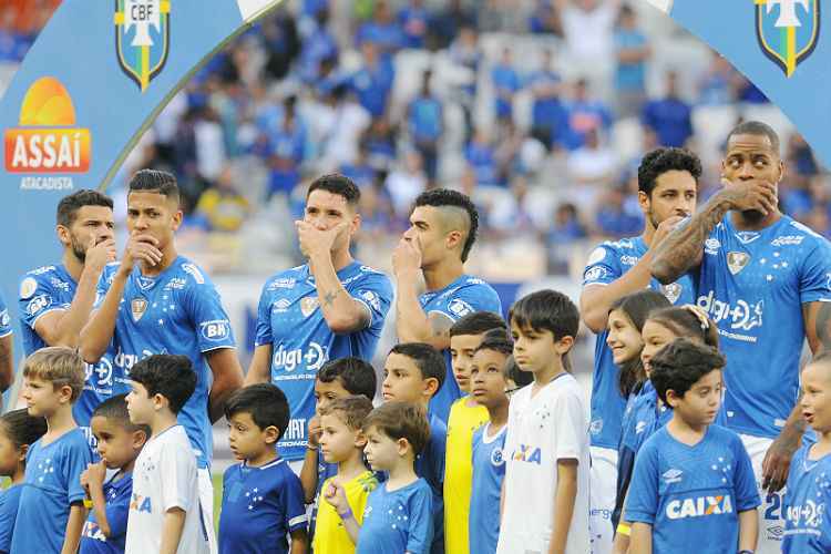Jogadores com a mão na boca antes do jogo deste domingo