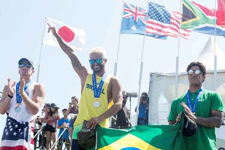 Ítalo Ferreira, campeão, segura a bandeira brasileira com Gabriel Medina, bronze