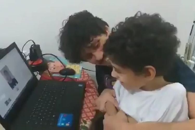Bento ao lado do pai, João de Andrade, assistindo ao vídeo de Neymar