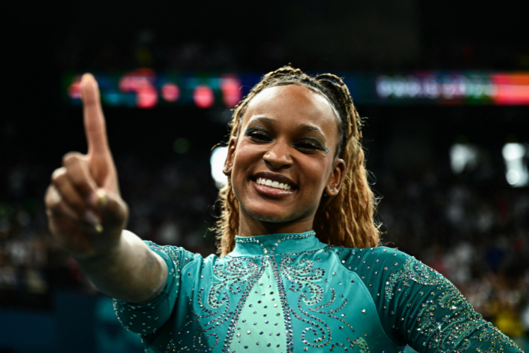 Rebeca Andrade no pódio sendo reverenciada por Simone Biles e Jordan Chiles